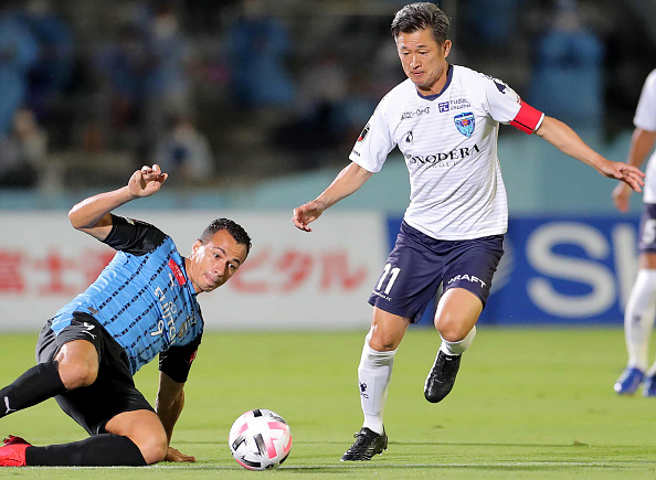 -L'attaquant du Yokohama FC Kazuyoshi Miura est abordé par l'attaquant de Kawasaki Frontale Leandro Damiao le 23 septembre 2020. Photo par STR / JIJI PRESS / AFP via Getty Images.