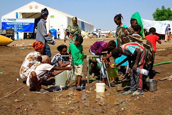 Ethiopian refugees who have fled the Tigray conflict, fill bottles and containers with water after arriving at a transit centre in the Sudanese border town of Hamdayit on November 27, 2020. - Over 43,000 refugees have crossed into Sudan since fighting broke out in Tigray on November 4, the UN High Commissioner for Refugees Filippo Grandi said, as he visited Sudanese camps crammed with those fleeing the conflict in northern Ethiopia. Hundreds have been killed in fighting between the federal government of Ethiopia's Prime Minister Abiy Ahmed and dissident forces of the regional ruling party, the Tigray People's Liberation Front (TPLF). (Photo by ASHRAF SHAZLY / AFP) (Photo by ASHRAF SHAZLY/AFP via Getty Images)