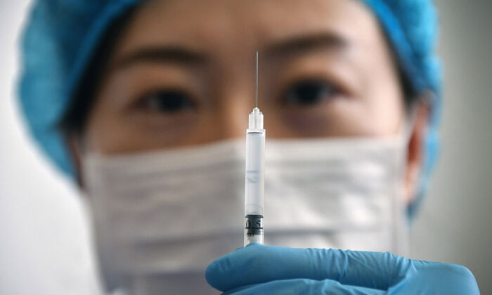 Une employée médicale montre une seringue contenant un vaccin dans un centre de santé de la ville de Yantai, dans la province du Shandong, au nord de la Chine, le 5 janvier 2021. (STR/AFP via Getty Images)