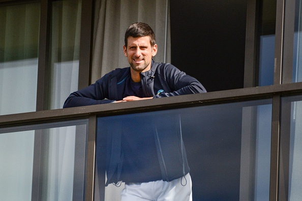 -Le joueur de tennis numéro un mondial Novak Djokovic, de Serbie, depuis le balcon de son hôtel le dernier jour de sa quarantaine de deux semaines à Adélaïde le 28 janvier 2021. Photo by Brenton Edwards / AFP via Getty Images.