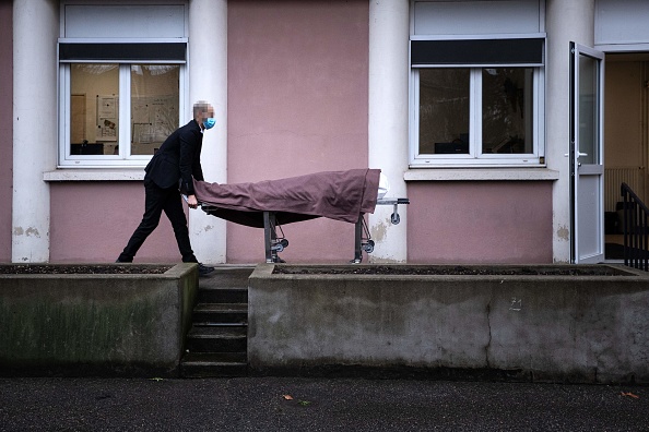 Un employé d'un salon funéraire utilise un chariot pour déplacer un corps hors de la chambre mortuaire de l'hôpital Beaujon AP-HP (Assistance Publique - Hopitaux de Paris) à Paris, le 27 janvier 2021. 
  (JOEL SAGET/AFP via Getty Images)