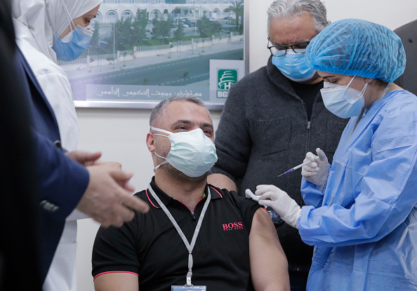 -Le chef de l'unité de soins intensifs de l'hôpital libanais Rafik Hariri, Mahmoud Hassoun, reçoit le premier vaccin du vaccin COVID-19. Photo par Anwar Amro / AFP via Getty Images.