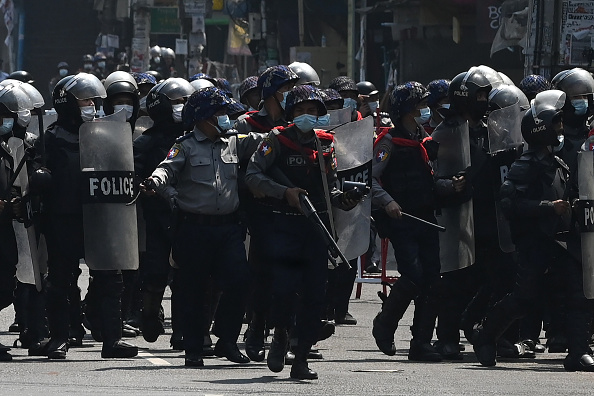 -La police anti-émeute marche sur une route pour empêcher les manifestants de tenir une manifestation à Yangon le 26 février 2021. Photo par Sai Aung Main / AFP via Getty Images.