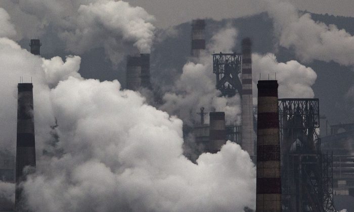 Nuages de pollution provenant de cheminées et d'un générateur au charbon dans une usine sidérurgique de la province industrielle de Hebei, en Chine, le 19 novembre 2015. (Kevin Frayer/Getty Images)