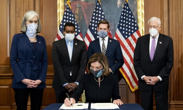 La présidente de la Chambre Nancy Pelosi (Parti démocrate-Californie) signe un article de destitution contre le président Donald Trump au Capitole américain à Washington, le 13 janvier 2021. (Stefani Reynolds/Getty Images)