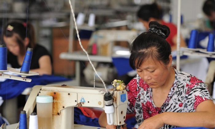 Des ouvriers travaillent dans une usine de vêtements à Hefei, dans la province d'Anhui, dans l'Est de la Chine. L'industrie chinoise de la confection connaît un ralentissement. (STR/AFP/Getty Images)