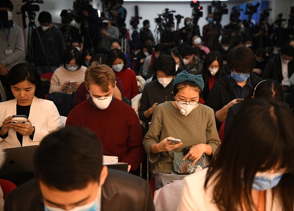 -Les journalistes portent des masques protecteurs lors d'une conférence de presse de la Commission nationale de la santé à Pékin le 27 janvier 2020. Photo de Noel Celis / AFP via Getty Images.