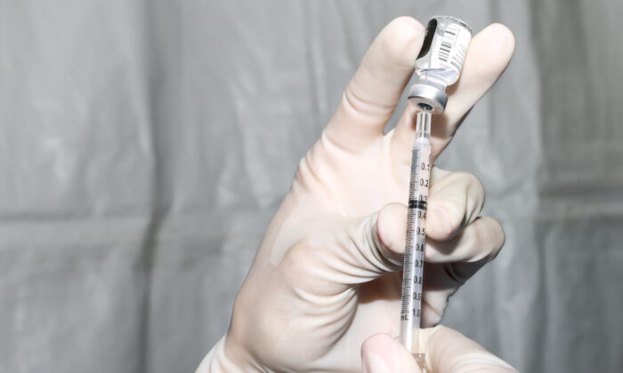 Un technicien en pharmacie prépare une dose du vaccin Covid-19 de Pfizer-BioNTech lors d'une vaccination de masse sur le parking de Coors Field à Denver, Colorado, le 20 février 2021. (Michael Ciaglo/Getty Images)