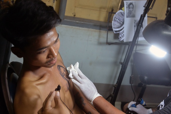 -Hein Yar Zar, le petit ami de la défunte manifestante birmane Mya Thwate Thwate Khaing, décédée, se fait tatouer son portrait sur la poitrine à Naypyidaw le 24 février 2021. Photo par STR / AFP via Getty Images.