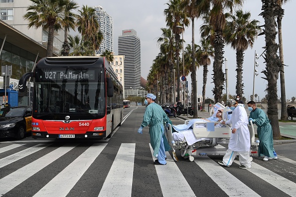 -Le personnel médical de l'hôpital Del Mar ramène un patient du COVID-19, à l'hôpital après avoir pris l'air au bord de la mer, à Barcelone le 4 mars 2021. Photo de Lluis Gene / AFP via Getty Images.