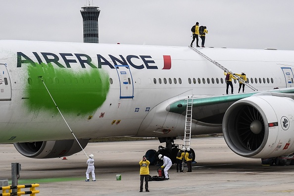 Des membres de Greenpeace peignent en vert un avion d'Air France garé sur le tarmac pour réclamer la réduction du trafic aérien face aux défis climatiques. (Photo : ALAIN JOCARD/AFP via Getty Images)