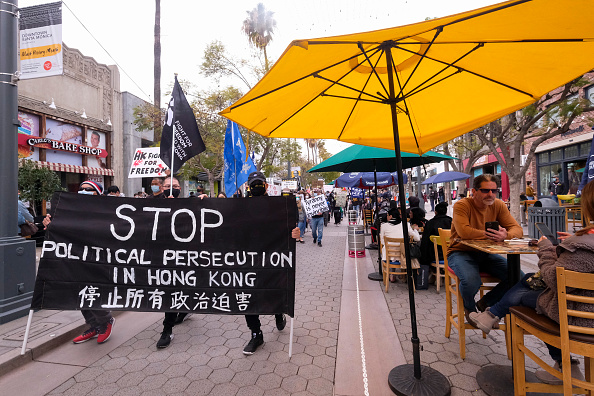 -Les habitants de Hong Kong lors d'une manifestation flash mob pour montrer leur solidarité avec les 47 militants pro- démocratie à Hong Kong, le 7 mars 2021. Photo de Ringo Chiu / AFP via Getty Images.