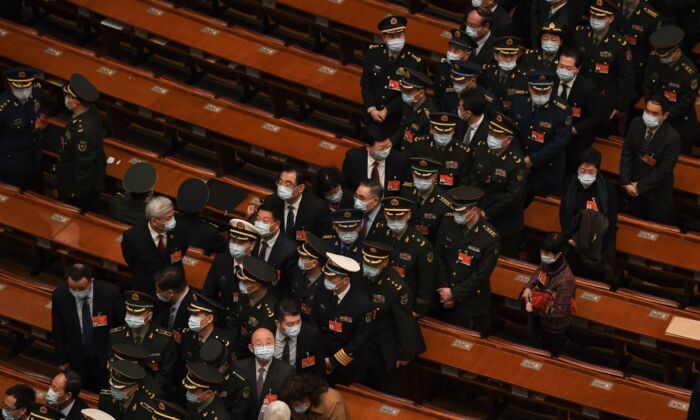 Des délégués militaires partent après la conférence de l'assemblée législative chinoise approuvée par les députés, au Grand Hall du Peuple à Pékin, en Chine, le 8 mars 2021. (Noel Celis/AFP via Getty Images)