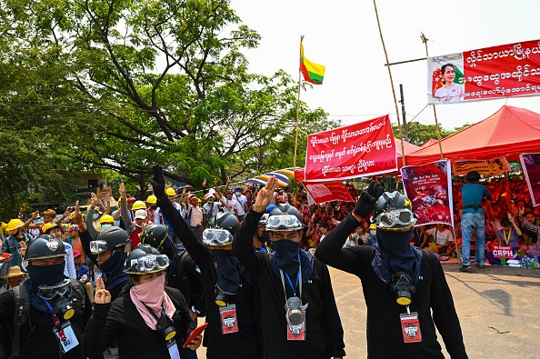 -Les manifestants font le salut à trois doigts à Yangon le 13 mars 2021, alors que les forces de sécurité continuent de réprimer. Photo par STR / AFP via Getty Images.