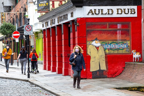 Des piétons passent devant le pub Auld Dubliner, fermé en raison de Covid-19, dans le quartier de Temple Bar du centre-ville de Dublin le 15 mars 2021. (Photo : PAUL FAITH/AFP via Getty Images)