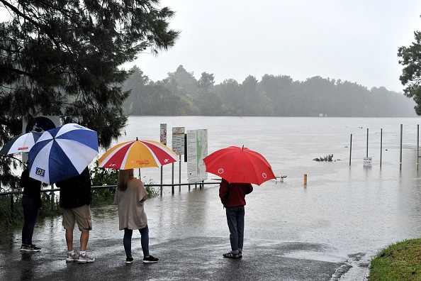 -Les résidents regardent la rivière Nepean gonflée lors de fortes pluies dans l'ouest de Sydney le 20 mars 2021. Photo par Farooq Khan / AFP via Getty Images.