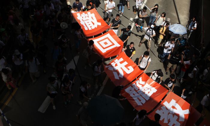 Des manifestants affichent une bannière indiquant « retirez l'éducation par lavage de cerveau » lors d'une manifestation contre les efforts du gouvernement pour mettre en place une éducation nationale à Hong Kong, le 29 juillet 2012. (Dale de la Rey/AFP/GettyImages)
