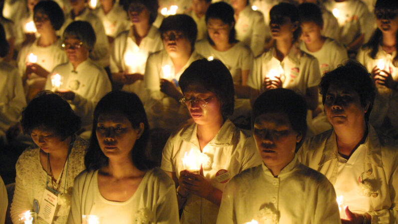Des pratiquants du Falun Gong tiennent des bougies lors d'une veillée aux chandelles en hommage aux personnes battues et torturées à mort en Chine, à Washington, le 19 juillet 2001. (Alex Wong/Getty Images)