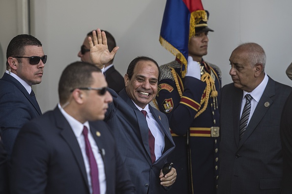 -Le président égyptien Abdel Fattah al-Sissi fait signe à son arrivée pour la cérémonie d'ouverture d'une nouvelle voie navigable sur le canal de Suez, le 6 août 2015, dans la ville portuaire d'Ismailiya. Photo Khaled Desouki /AFP via Getty Images.