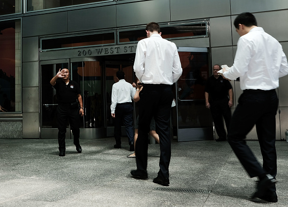 Les gens marchent au siège de Goldman Sachs à New York. Treize salariés de première année affirment travailler en moyenne 98 heures par semaine depuis le début de l'année et aller se coucher en moyenne à 3 heures du matin. (Photo : Spencer Platt/Getty Images)