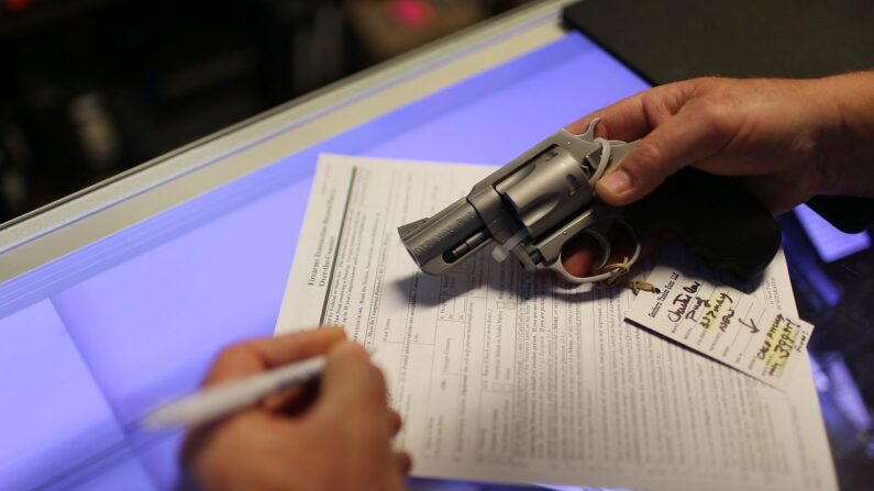 Un client remplit le formulaire fédéral de vérification d'antécédents alors qu'il achète une arme de poing à Delray Beach, en Floride, le 5 janvier 2016. (Joe Raedle/Getty Images)
