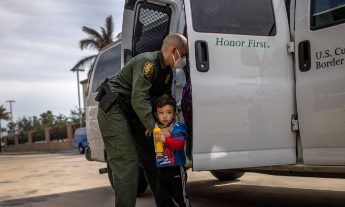Un agent de la patrouille frontalière conduit une famille entrée illégalement aux États-Unis à une station de bus à Brownsville, au Texas, le 26 février 2021. (John Moore/Getty Images)
