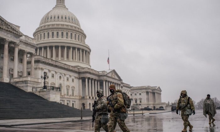 Des membres de la Garde nationale marchent dans l'enceinte du Capitole des États-Unis, à Washington, le 13 février 2021. (Brandon Bell/Getty Images)