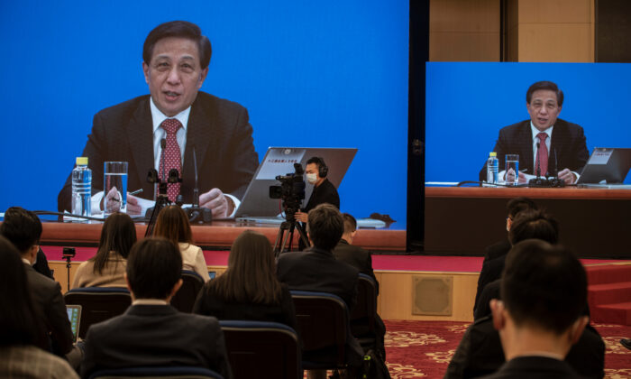 Le porte-parole deu Congrès national des peuples nationaux, Zhang Yesui, est aperçu sur de grands écrans lors d'une conférence de presse vidéo, à titre de précaution en raison du Covid-19, à Pékin, en Chine, le 4 mars 2021. (Kevin Frayer/Getty Images)