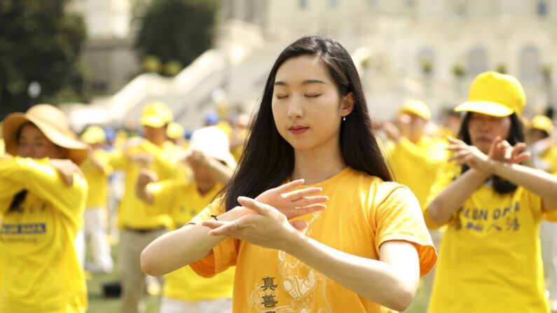 Des pratiquants de Falun Gong effectuent des exercices lors d'un rassemblement commémorant le 20e anniversaire de la persécution du Falun Gong en Chine, sur la pelouse ouest du Capitole, le 18 juillet 2019. (Samira Bouaou/The Epoch Times)