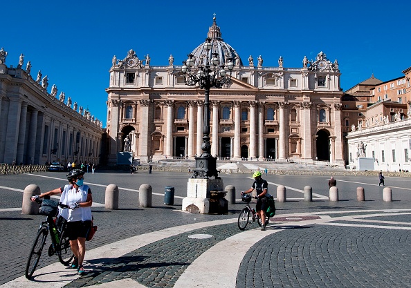 Des personnes à vélos sur la place Saint-Pierre du Vatican le 8 octobre 2020. Photo par Tiziana FABI / AFP via Getty Images.