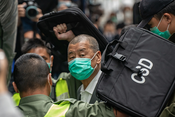 Jimmy Lai, magnat des médias prodémocratie de Hong Kong, est conduit dans un fourgon de police alors qu'il se rend au tribunal pour être inculpé en vertu de la nouvelle loi controversée sur la sécurité nationale imposée par Pékin, le 12 décembre 2020. (Peter Parks/AFP via Getty Images)