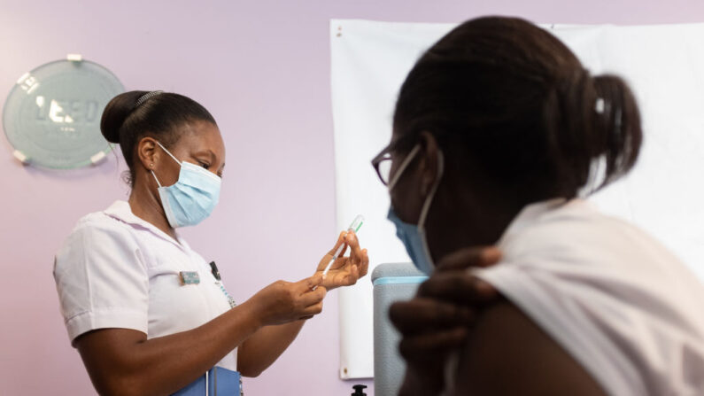 Un agent de santé se prépare à vacciner une infirmière de première ligne avec le vaccin Oxford/AstraZeneca à l'hôpital Ridge d'Accra, au Ghana, le 2 mars 2021. (NIPAH DENNIS/AFP via Getty Images)