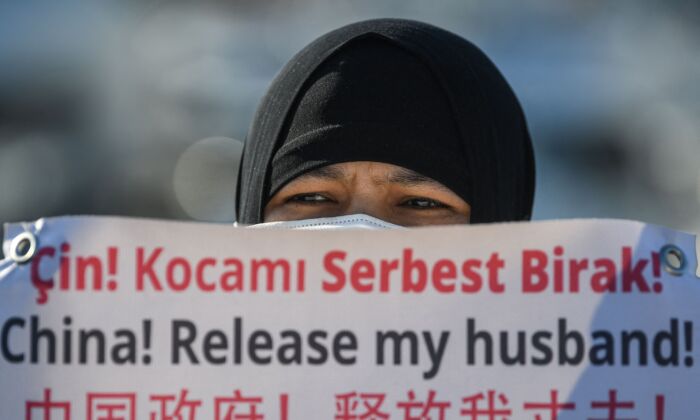 Une Ouïghoure tient une pancarte demandant au régime chinois de libérer son mari lors d'un défilé près du consulat chinois à Istanbul, en Turquie, le 22 février 2021. (Ozan Kose/AFP via Getty Images)