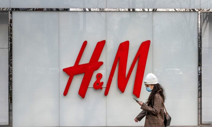 Une femme passe devant le magasin de vêtements H&M dans une zone commerciale de Pékin, le 25 mars 2021. (Kevin Frayer/Getty Images)
