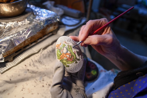 -Tunde Csuhaj, créatrice d'œufs de Pâques décorés artistiquement, peint un œuf d'oie dans son atelier de la ville de Szekszárd, en Hongrie, le 29 mars 2021. Photo Attila Kisbenedek / AFP via Getty Images.