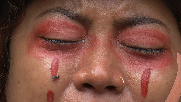-Le 1er avril 2021 un manifestant, maquillé en rouge simule les larmes de sang, il pleure lors d'une manifestation à Yangon. Photo par - / AFP via Getty Images.