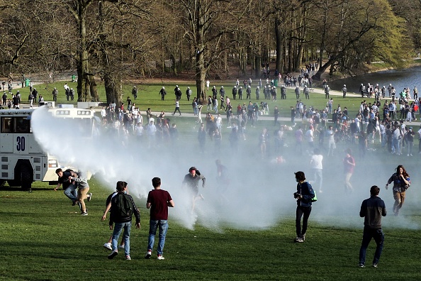 Des spectateurs et des manifestants sont trempés par un canon à eau de la police belge alors que des policiers les encerclent au parc du Bois de la Cambre, à Bruxelles, le 1er avril 2021 lors d'un rassemblement non autorisé, (Photo : FRANCOIS WALSCHAERTS/AFP via Getty Images)