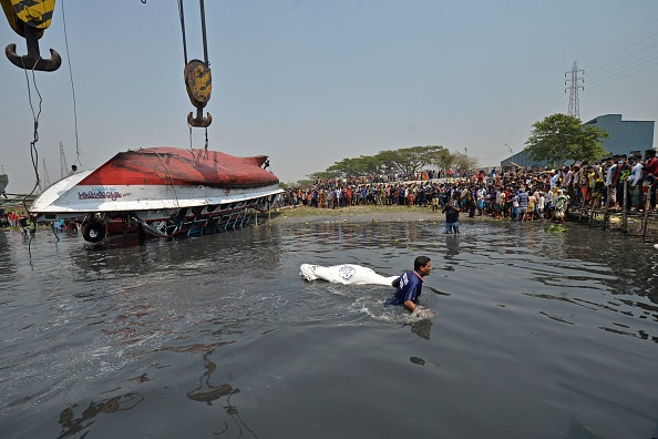 -Un plongeur tire un cadavre du bateau qui a chaviré dans la rivière Shitalakshya, à Narayanganj, le 5 avril 2021. Photo de Munir Uz zaman / AFP via Getty Images.