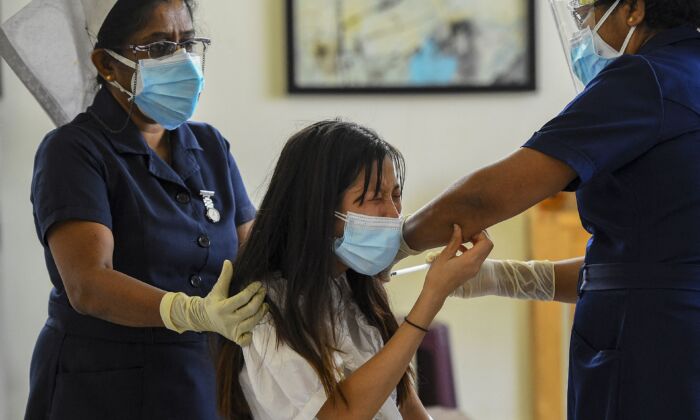 Une infirmière inocule le vaccin Sinopharm de fabrication chinoise à une Chinoise vivant au Sri Lanka, dans les locaux du projet Colombo Port City, à Colombo, au Sri Lanka, le 6 avril 2021. (Ishara S. Kodikara/AFP via Getty Images)