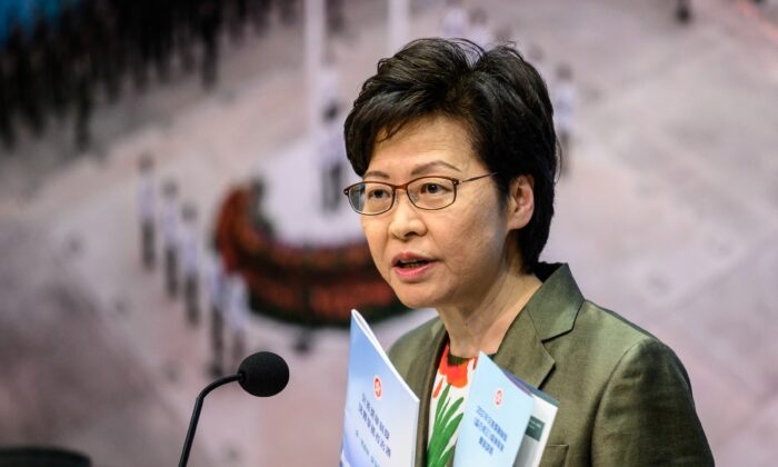 La dirigeante de l'exécutif de Hong Kong, Carrie Lam, tient un dépliant pour le "projet de loi 2021 sur l'amélioration du système électoral (amendements consolidés)" alors qu'elle s'exprime lors d'une conférence de presse au siège du gouvernement à Hong Kong, le 13 avril 2021. (Antoine Wallace/AFP via Getty Images)