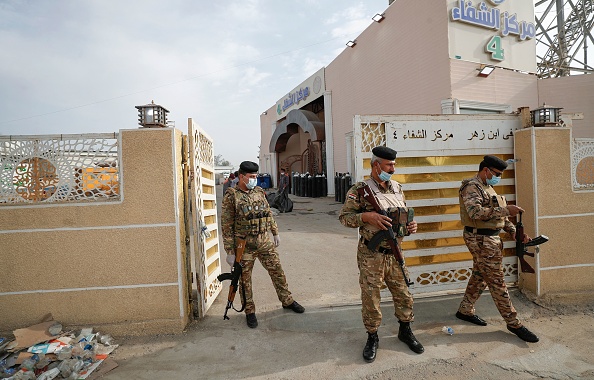 -Des policiers irakiens se tiennent à la porte de l'hôpital Ibn Al- Khatib de Bagdad, le 25 avril 2021, après qu'un incendie a éclaté dans l'établissement médical. Photo AHMAD AL-RUBAYE/AFP via Getty Images.