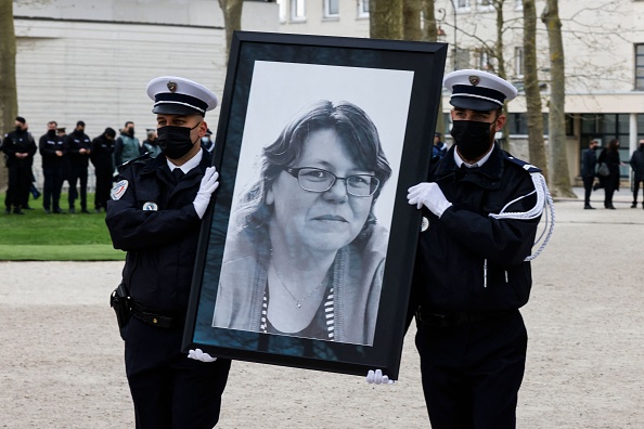 Des policiers tiennent le portrait de Stéphanie Monferme âgée de 49 ans, mortellement poignardée le 23 avril à Rambouillet. (Photo : LUDOVIC MARIN/POOL/AFP via Getty Images)
