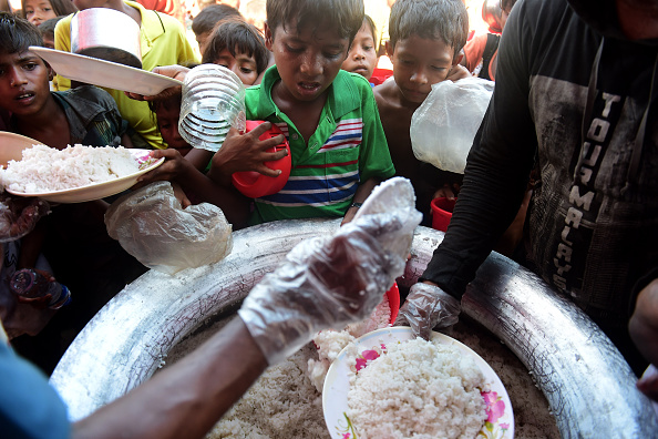 -Des enfants réfugiés reçoivent une aide alimentaire au camp de de Thankhali, dans le district d'Ukhia au Bangladesh. Photo par Munir UZ ZAMAN / AFP via Getty Images.