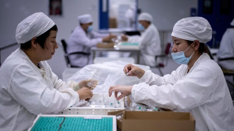 Des ouvriers emballent un vaccin contre la rage dans un laboratoire où des chercheurs tentent de développer un vaccin contre le coronavirus COVID-19, à Shenyang, dans la province chinoise du Liaoning (nord-est), le 9 juin 2020. (Noel Celis/AFP via Getty Images)
