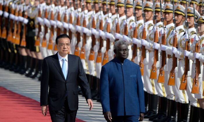 Le Premier ministre des îles Salomon Manasseh Sogavare (à droite) et le Premier ministre chinois Li Keqiang inspectent les gardes d'honneur lors d'une cérémonie de bienvenue au Grand Hall du Peuple à Pékin, le 9 octobre 2019. (Wang Zhao/AFP via Getty Images)