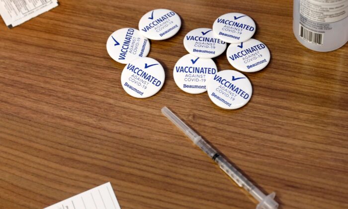 Des pins pour les travailleurs de Beaumont Health Care après avoir reçu leur première dose du vaccin contre le Covid-19 de Pfizer/BioNTech, à côté d'une seringue dans leur centre de service à Southfield, Michigan, le 15 décembre 2020. (Jeff Kowalsky/AFP via Getty Images)