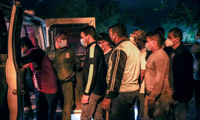 Des agents de la patrouille frontalière mettent aux arrêts des immigrants illégaux après qu'ils ont traversé le Rio Grande du Mexique à Delaware, au Texas, le 23 mai 2021. (Charlotte Cuthbertson/Epoch Times)