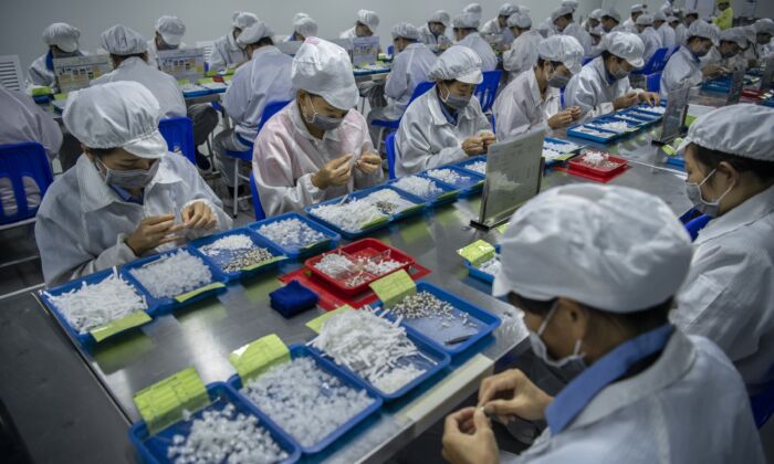 Des ouvriers assemblent des pièces pour les e-cigarettes sur la ligne de production de KangerTech, l'un des principaux fabricants chinois de produits de vapotage à Shenzhen, en Chine, le 24 septembre 2019. (Kevin Frayer/Getty Images)