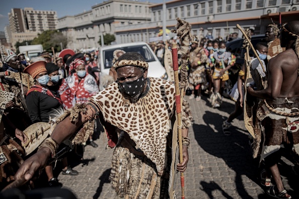 -Un homme faisant partie des régiments zoulous, ouvre la voie au corbillard devant la morgue de Johannesburg, le 5 mai 2021. Photo par Luca Sola / AFP via Getty Images.