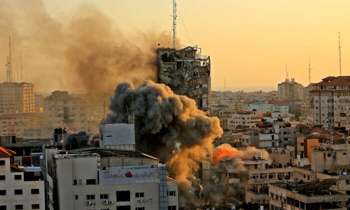Une épaisse fumée et des flammes s'élèvent de la tour Al-Sharouk alors qu'elle s'effondre après avoir été touchée par une frappe aérienne israélienne, dans la ville de Gaza, le 12 mai 2021. (Qusay Dawud/AFP via Getty Images)